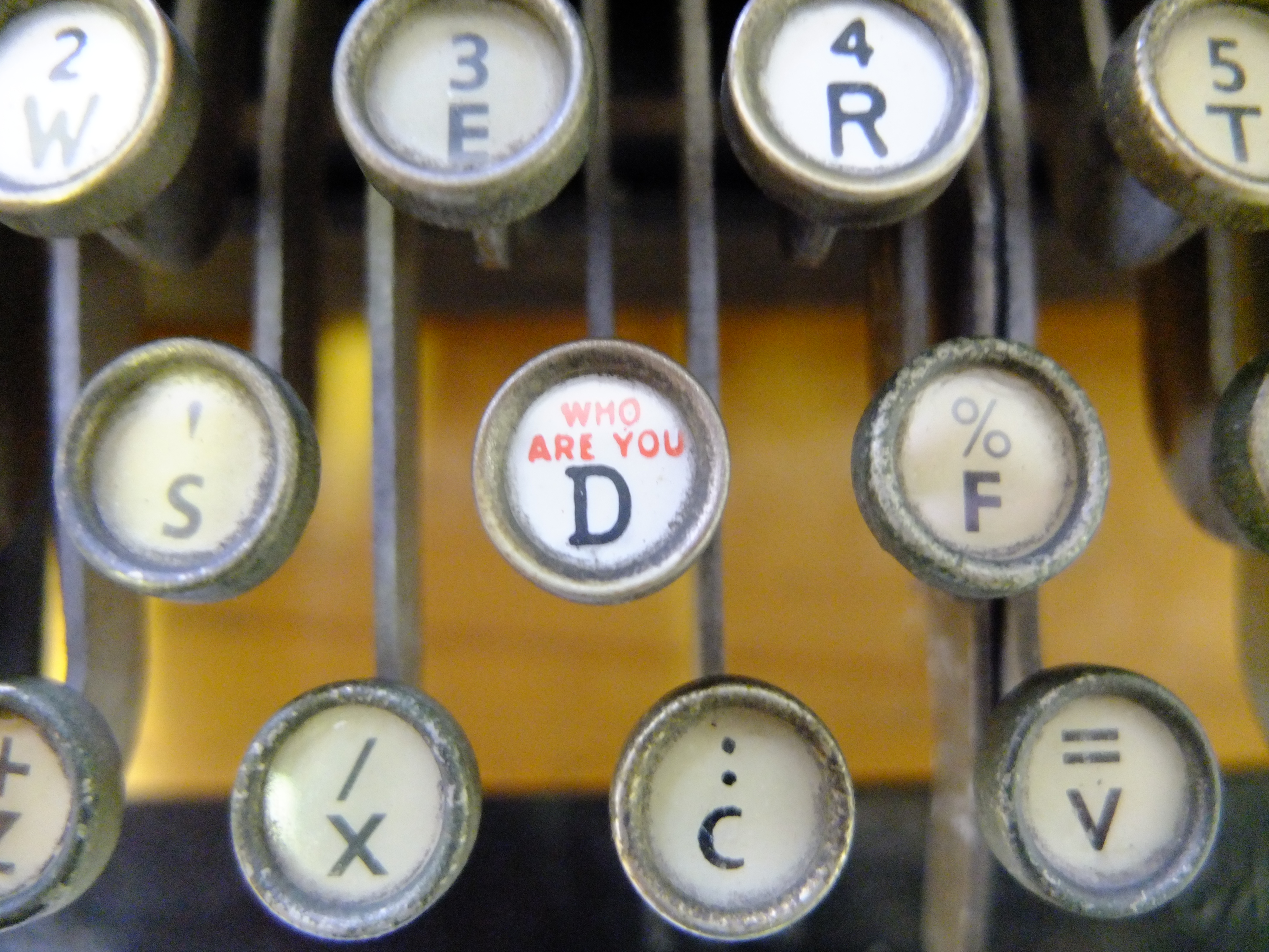 Typewriter keys. One says WHO ARE YOU?